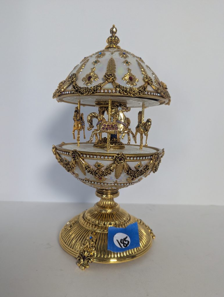 Gold and white House of Fabergé Imperial Carousel Egg on a stand