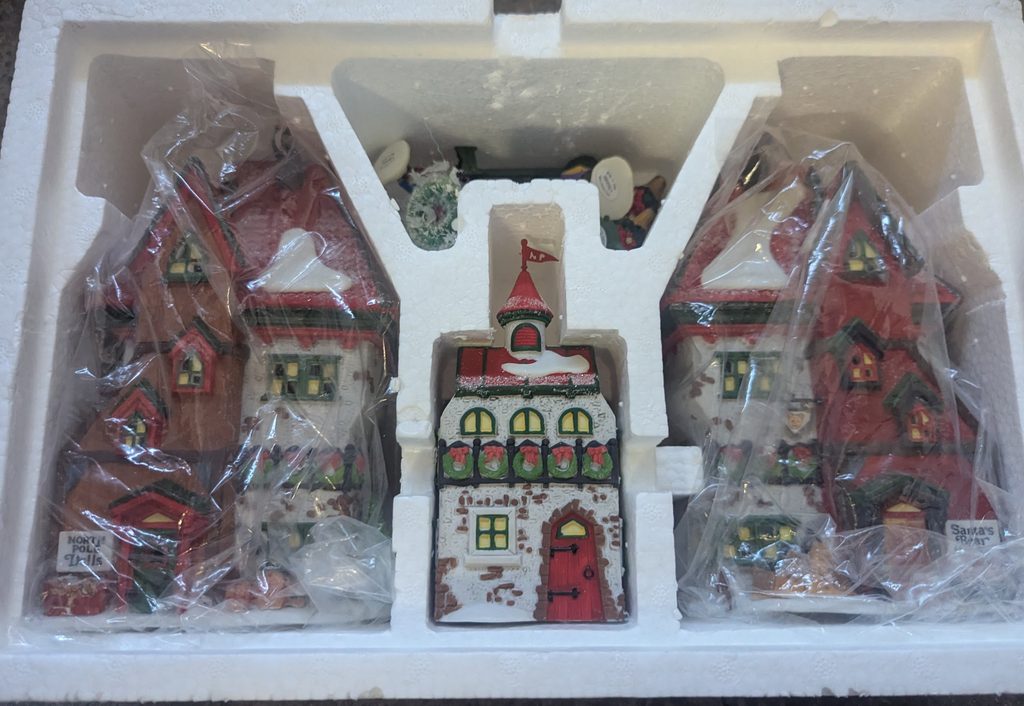 Three Department 56 village buildings in protective packaging