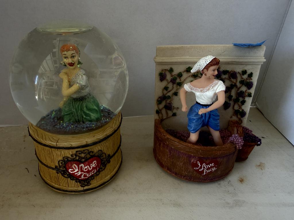 Lot 161: I Love Lucy grape-stomping collectibles, including a musical globe and a figurine of Lucy standing in a grape barrel.
