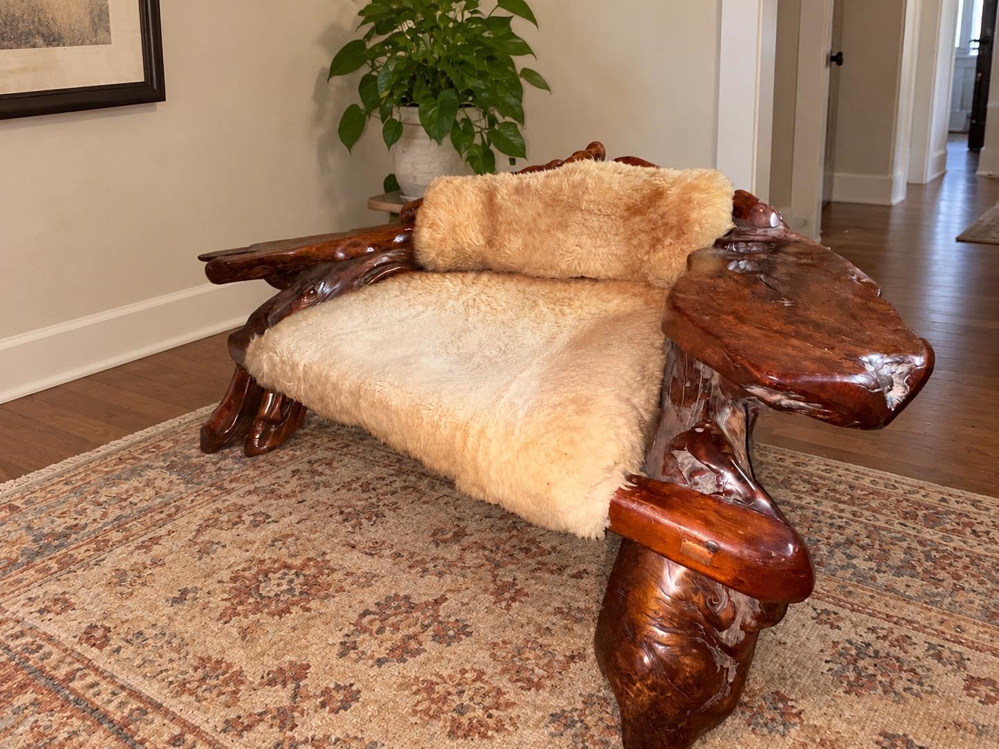 Burl Bros redwood lounge chair with cream upholstery and sculptural wood arms in the Burlwood and Collectibles Auction.